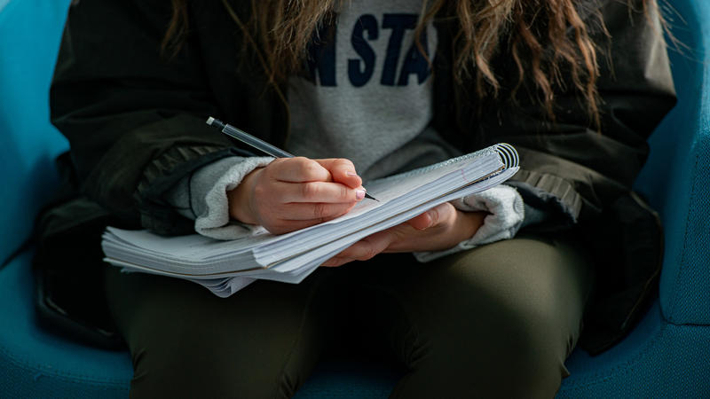 Student writing on a notebook